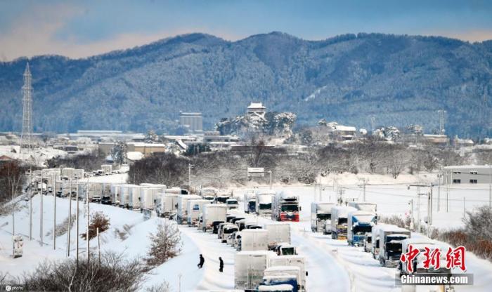 当地时间2021年1月10日，日本富山县，大雪天行路难，东海北陆自动车道上车辆排起长龙。 图片来源：ICphoto