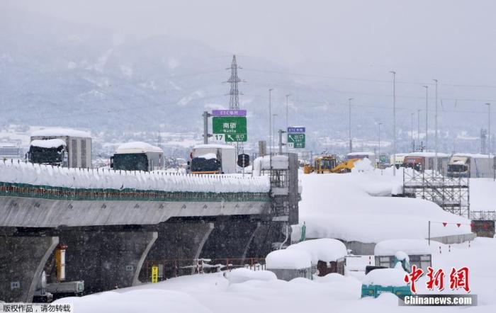 图为当地时间1月10日，日本富山县南藤市的东海-北库高速公路上，车辆被积雪覆盖。