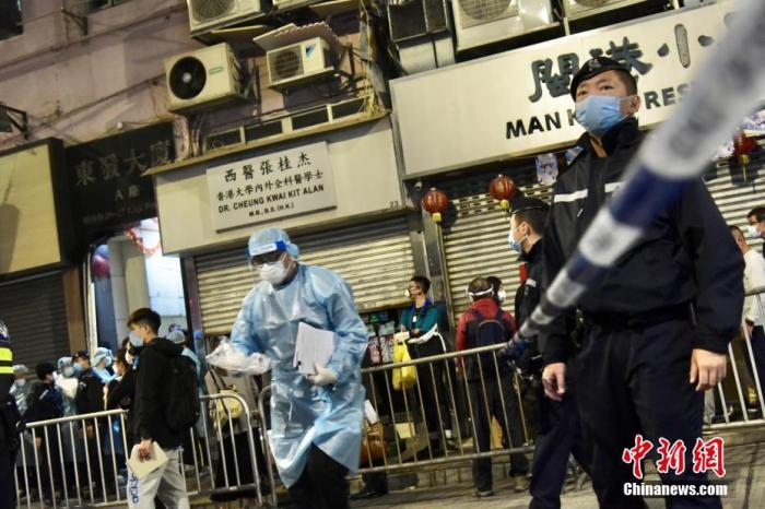 1月28日，香港特区政府自下午7时起在北角指明“受限区域”，即锦屏街东发大厦A、B、C和D座内的人士须留在其处所并按特区政府安排接受强制检测。受检人士须在其处所等候，直至区内所有已识别的受检人士完成检测，而相关检测结果亦已获大致确定，方可离开其处所。图为警方人员到场设置封锁线。 中新社记者 李志华 摄