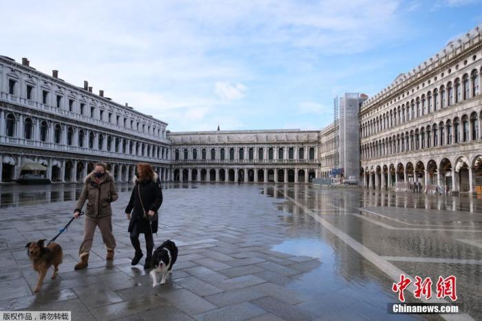 图为当地时间1月31日，意大利威尼斯，戴着口罩的民众穿过空旷的圣马可广场。