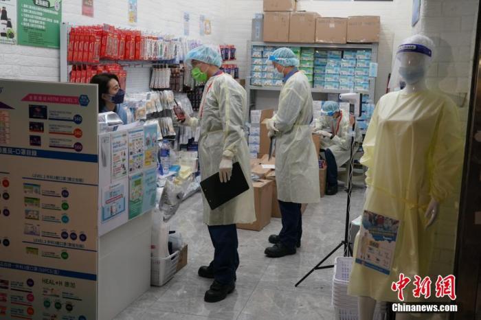 2月1日晚7时，香港特区政府宣布将尖沙咀金銮大厦列入指明“受限区域”，该大厦居民须留在其处所并接受强制检测。图为工作人员进入“受限区域”的商铺进行登记调查。
<a target='_blank' href='http://www.chinanews.com/'>中新社</a>记者 张炜 摄