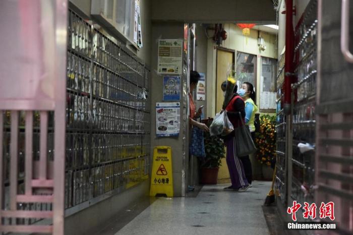 2月8日下午，香港鲗鱼涌惠利大厦新增3宗初步阳性病例，特区政府卫生署卫生防护中心人员到场察看环境。图为市民返回鲗鱼涌惠利大厦住所。
<a target='_blank' href='http://www.chinanews.com/'>中新社</a>记者 李志华 摄