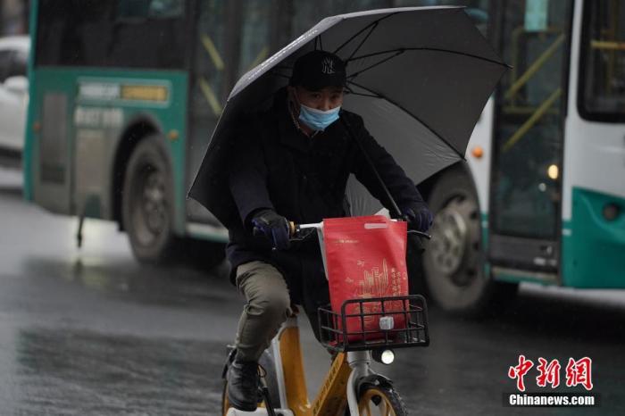 2月8日，立春后的昆明迎来降雨天气，气温骤降，瞬间返冬。图为市民撑伞骑车。<a target='_blank' href='http://www.chinanews.com/'>中新社</a>记者 刘冉阳 摄