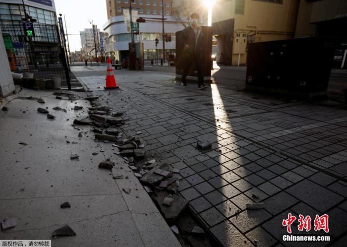 当地时间2月14日，日本福岛县磐城市，一座建筑物的外墙因强烈地震而倒塌，碎片散落一地。