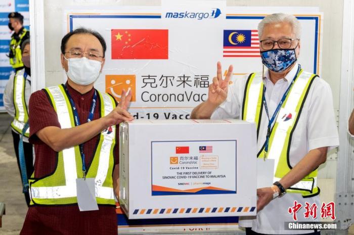2月27日，北京科兴中维生物技术有限公司生产的首批新冠疫苗半成品运抵马来西亚吉隆坡国际机场，正式交付马来西亚发马公司。图为中国驻马来西亚大使欧阳玉靖(左)向马国防部高级部长沙布里(右)象征性移交疫苗样品。
<a target='_blank' href='http://www.chinanews.com/'>中新社</a>发 中国驻马大使馆 供图
