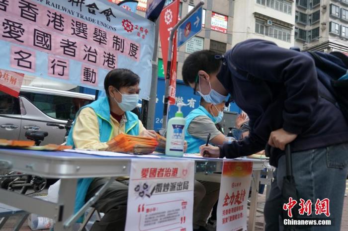 3月6日，香港湾仔街头，市民在香港工联会街站签名，支持完善香港选举制度，落实“爱国者治港”。 <a target='_blank' href='http://www.chinanews.com/'>中新社</a>记者 张炜 摄