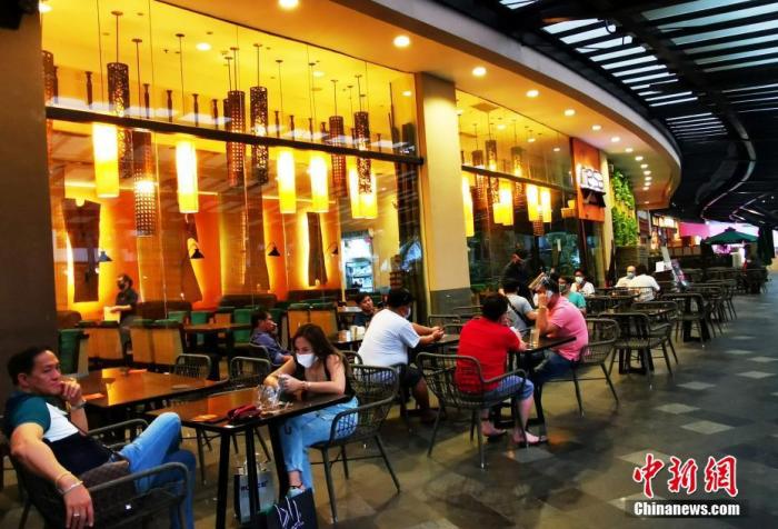 当地时间3月22日，菲律宾首都大马尼拉地区实施全面社区隔离，再度禁止餐厅、咖啡馆堂食，只允许外卖和露天就餐。图为位于马尼拉CBD马卡蒂绿带商圈的一家著名连锁餐厅禁止堂食，顾客在露天餐位按照社区隔离距离要求，静候就餐。
<a target='_blank' href='http://www.chinanews.com/'>中新社</a>记者 关向东 摄