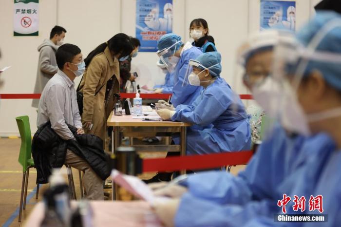 资料图：北京林业大学疫苗接种点内，工作人员对接种者的基本信息进行询问。中新社记者 蒋启明 摄