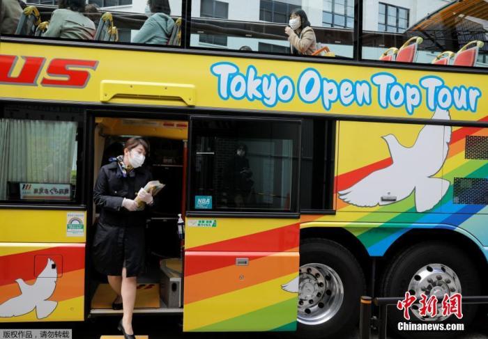 当地时间3月22日，日本东京解除紧急状态，旅游业逐步恢复，民众戴口罩搭乘观光车赏樱花。