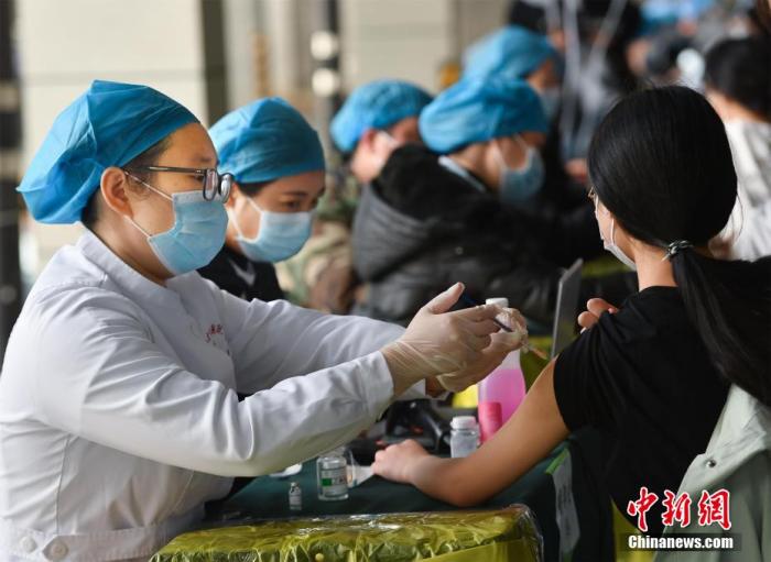 3月25日，在武汉大学卓尔体育馆，学生有序排队，接种新冠疫苗。李晗 摄