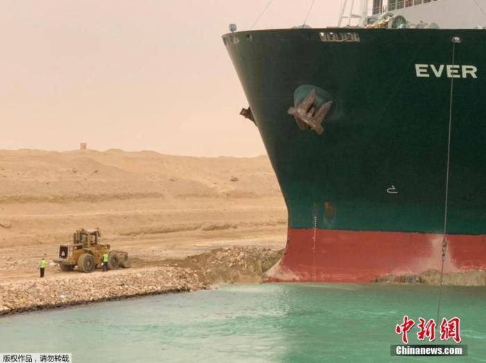 图为在苏伊士运河新航道搁浅的货船的船头被卡在岸边。