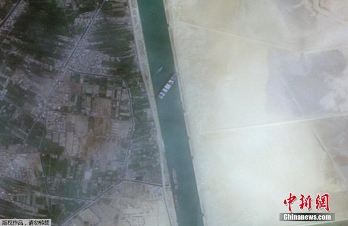 图为当地时间3月24日，在苏伊士运河新航道搁浅的货船。