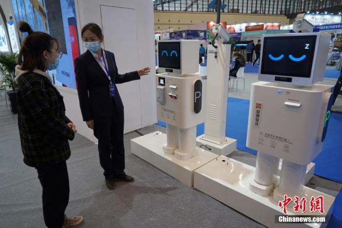 资料图：2021世界数字产业博览会在河南郑州举行，参观者了解可24小时值守的智能停车管理机器人。
<a target='_blank' href='/'>中新社</a>记者 李超庆 摄