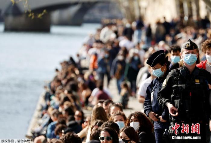 资料图：当地时间3月28日，法国巴黎，大批民众在塞纳河畔享受春日阳光。