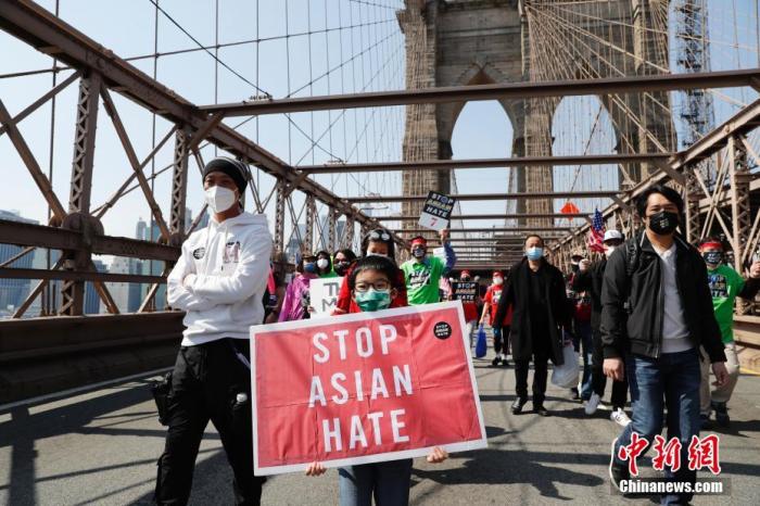 当地时间4月4日，纽约举行反仇恨亚裔大游行，上万民众手持标语在曼哈顿弗利广场集会后，游行穿过布鲁克林大桥至布鲁克林卡德曼广场。图为游行队伍中手持“停止仇恨亚裔”标语的亚裔孩童。 <a target='_blank' href='http://www.chinanews.com/'>中新社</a>记者 廖攀 摄