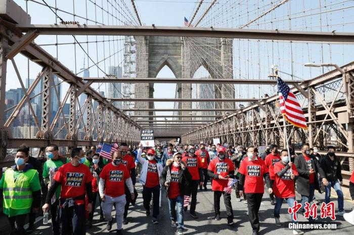 资料图：当地时间4月4日，纽约举行反仇恨亚裔大游行，上万民众手持标语在曼哈顿弗利广场集会后，游行穿过布鲁克林大桥至布鲁克林卡德曼广场。图为民众游行穿过布鲁克林大桥。<a target='_blank' href='http://www.chinanews.com/'><p  align=
