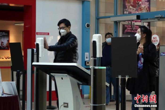 当地时间4月7日，加拿大多伦多一华人商场，顾客在入口处进行体温检测。