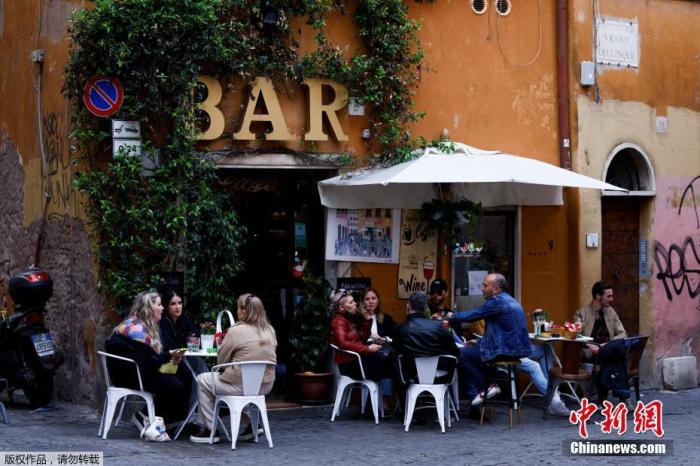 资料图：意大利民众在罗马酒吧的户外餐桌上就餐。