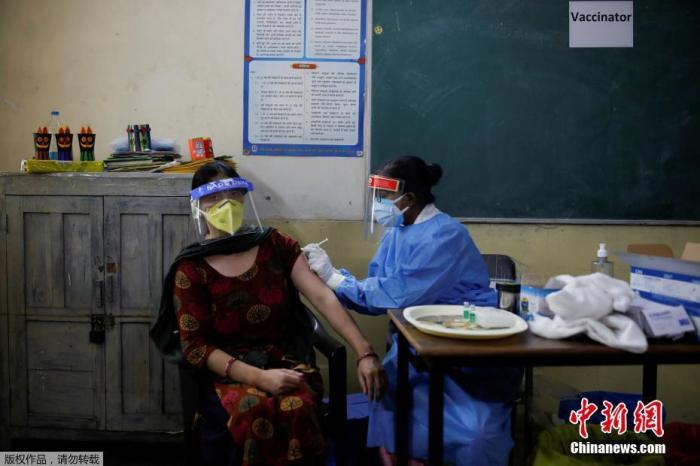 当地时间5月4日，印度新德里，人们带着防护口罩在疫苗接种中心等待接种印度自产的COVISHIELD新冠疫苗。据印度卫生部5月4日公布数据，过去24小时全国新增357229例确诊病例，累计达20282833例。这也是印度连续13天单日新增病例数在30万以上。