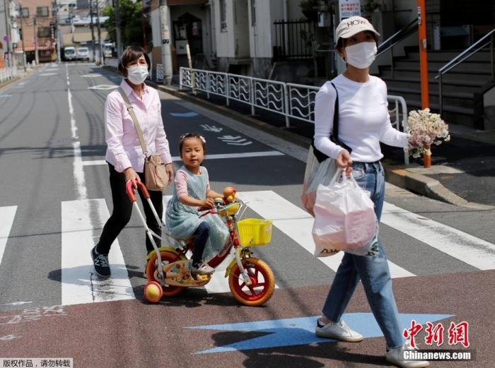 资料图：日本民众戴着口罩，在街头行走。
