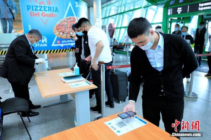 当地时间5月13日，在位于哈萨克斯坦首都努尔苏丹的纳扎尔巴耶夫机场，乘客扫描健康码识别健康状况。 中新社记者 张硕 摄