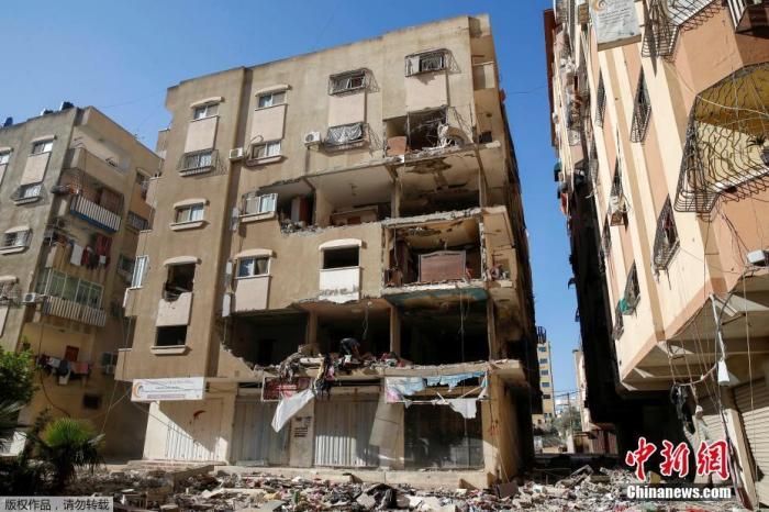 当地时间5月15日，巴以冲突期间，加沙地区当地民众在损毁的房屋内清理物品。