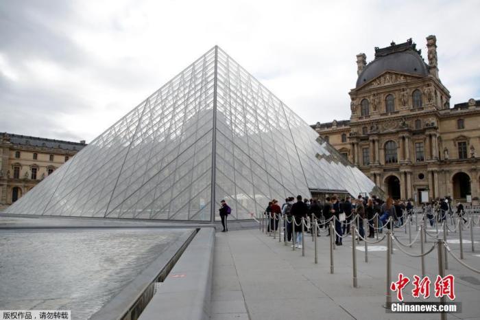 资料图：当地时间5月19日，法国巴黎，受疫情影响关闭了6个多月的卢浮宫重新对公众开放。图为参观者在卢浮宫玻璃金字塔入口处排队等待进入。