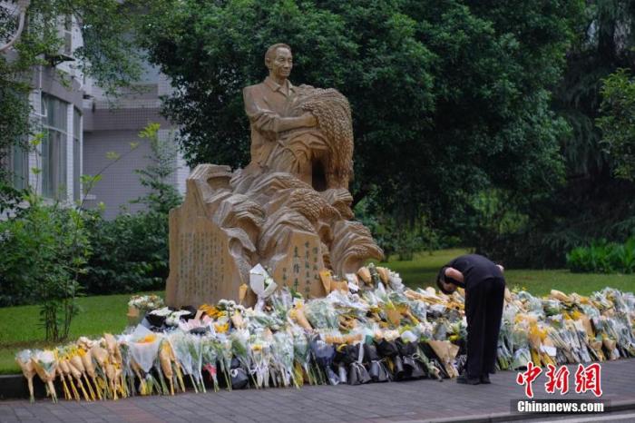 西南大学一位学生在袁隆平雕像前鞠躬。 何蓬磊 摄