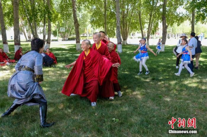 6月1日，西藏拉萨，西藏佛学院的少年活佛和拉萨市第一小学的孩子们一起玩“老鹰捉小鸡”的游戏。当日为“六一”国际儿童节，西藏佛学院与拉萨市第一小学举行联谊活动，佛学院的少年活佛与孩子们一起朗诵诗歌、表演节目、玩游戏等。 中新社记者 江飞波 摄