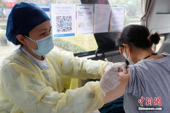 图为上海同仁医院医护人员，对市民进行接种工作。殷立勤 摄