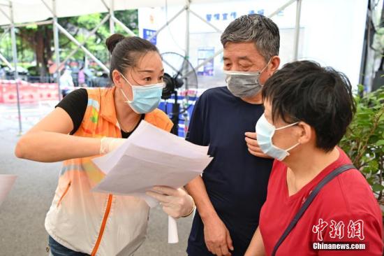 A staff member of No. 2 People's Hospital of Guangdong Province explains to an eldly woman about the COVID-19 vaccination in Guangzhou, Guangdong Province, July 1, 2021. (Photo/China News Service)