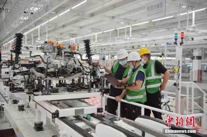 资料图：7月8日，在位于长春国际汽车城的一汽红旗新能源汽车工厂内，工作人员在进行设备调试。 张瑶 摄