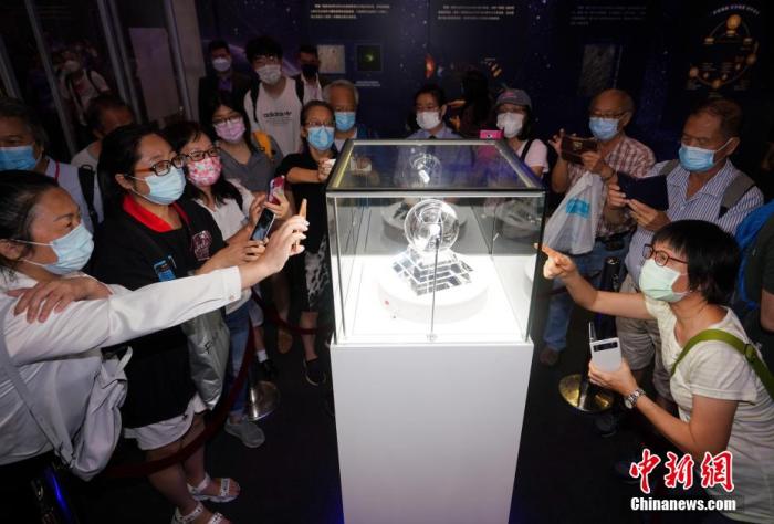 资料图：7月7日，“时代精神耀香江”之百年中国科学家主题展继续在香港会展中心举行。众多市民踊跃参观月壤。 张炜 摄
