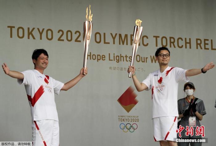 当地时间7月9日，东京奥运会圣火抵达日本东京都，圣火迎接仪式在驹泽奥林匹克公园体育场举行。图为火炬手们展示奥运圣火。