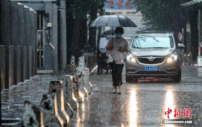 7月12日，北京朝阳区团结湖附近，市民冒雨出行。 中新社记者 贾天勇 摄