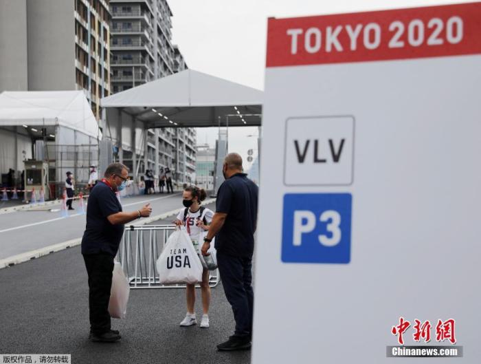 7月13日，日本东京奥运会运动员村正式开村，迎接来自世界各地的运动员入住。受新冠疫情影响，当日未举行入村仪式等庆典活动。图为一名美国队的工作人员出现在运动员村入口处。