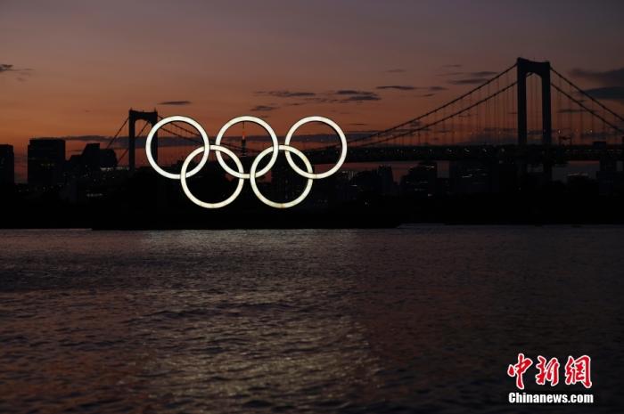 当地时间7月22日，晚霞映衬下的奥运五环，该五环标志位于日本东京湾台场滨海公园。第三十二届夏季奥运会将于7月23日在东京开幕。 /p中新社记者 富田 摄 　
