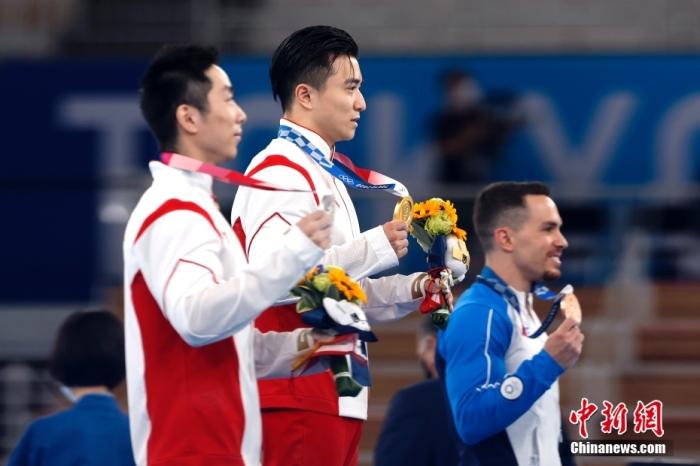 北京时间8月2日，在东京奥运会男子体操单项吊环的比赛中，中国选手刘洋以15.500分夺得冠军。这是中国代表团本届比赛的第26金。另一位中国选手尤浩获得亚军。图为刘洋(中)与尤浩(左)展示金银牌。 <a target='_blank' href='http://www.chinanews.com/'>中新社</a>记者 富田 摄