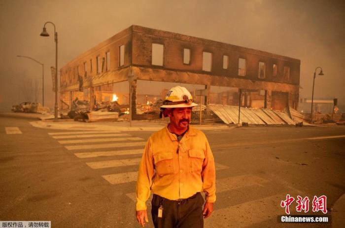 当地时间8月5日，山火肆虐过后，美国加利福尼亚州格林维尔镇大量建筑被焚毁。据当地工作人员介绍，大火烧毁了格林维尔的数十所房屋和企业，并继续向其他住宅社区蔓延。图为当地工作人员查看被焚毁的建筑。