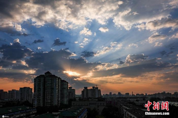 资料图：北京在经历强对流天气过后，迎来朝霞，一道金光洒在北京城上空。图片来源：ICphoto