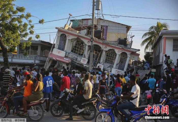当地时间8月14日，海地Les Cayes，人们聚集在倒塌的酒店周围。