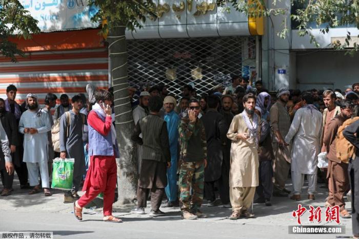 当地时间8月15日，阿富汗首都喀布尔，民众在银行外排队取钱。阿富汗塔利班发言人当天宣布，塔利班武装人员已进入首都喀布尔。