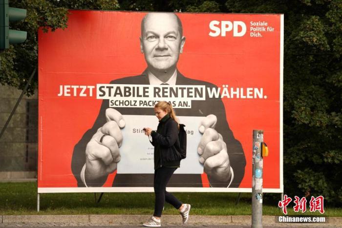 资料图：一名行人经过德国柏林街头的社民党总理候选人朔尔茨的竞选展板。<a target='_blank' href='/'>中新社</a>记者 彭大伟 摄
