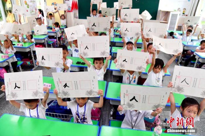 9月1日，小学一年级新生展示自己书写的“人”字。 张斌 摄