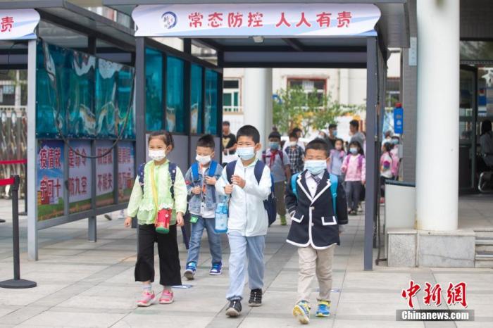 9月1日，学生戴着口罩进入校园。中新社记者 张云 摄