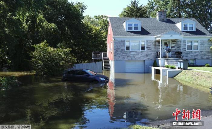 当地时间9月2日，受飓风“艾达”影响，美国纽约遭暴雨侵袭，一辆汽车停在被洪水淹没的房屋车道上。