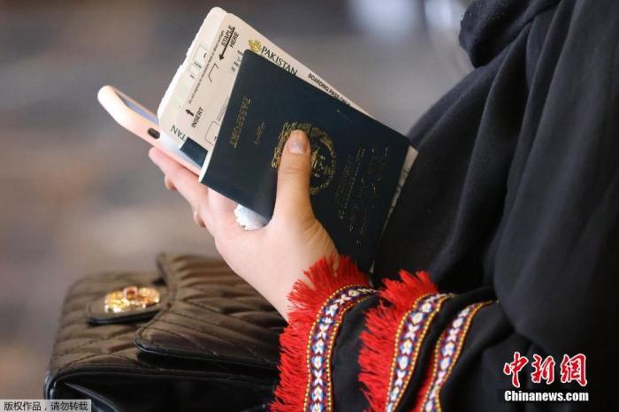 当地时间9月13日，阿富汗喀布尔机场，一名女性手持护照在航站楼候机。