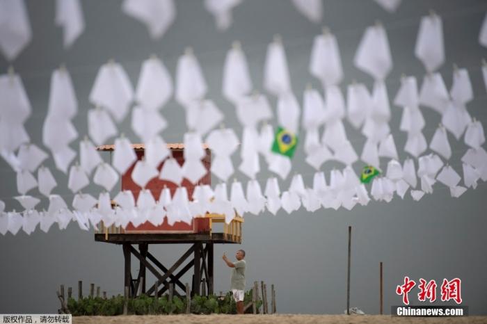 当地时间10月8日，巴西里约一民间组织为纪念死于新冠肺炎的60万巴西人，在科帕卡帕纳海竖起桅杆，并在上面悬挂600条白色手帕，活动组织者称这600条白手帕除了纪念病亡的60万同胞。