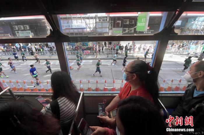 市民于电车内观看马拉松赛事。 李志华 摄