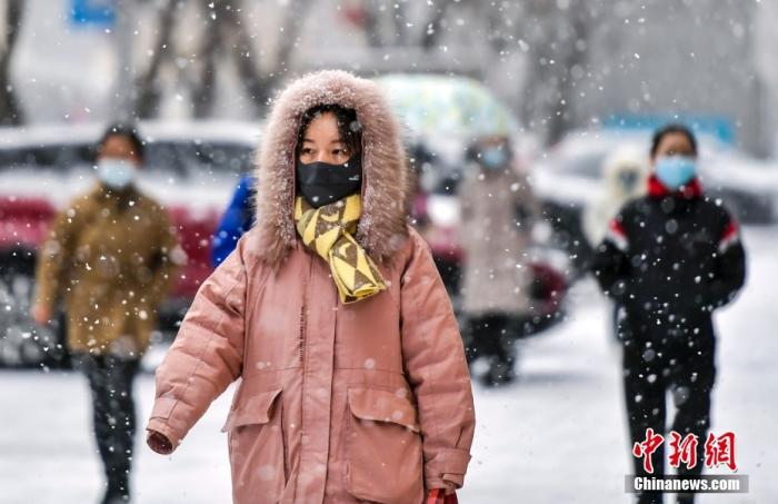 资料图：市民在降雪天气出行。 <a target='_blank' href='/'>中新社</a>记者 刘新 摄